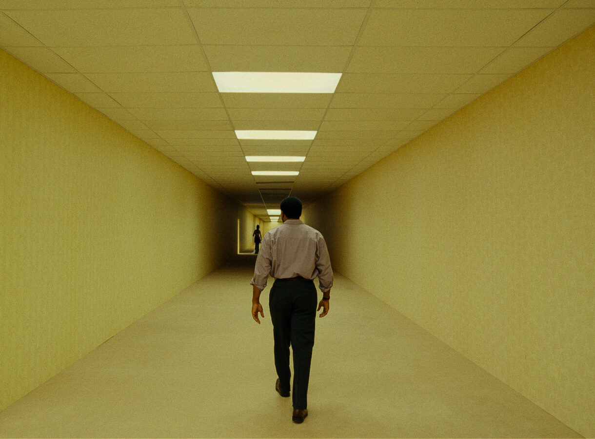 Person walking down a long, dimly lit corridor